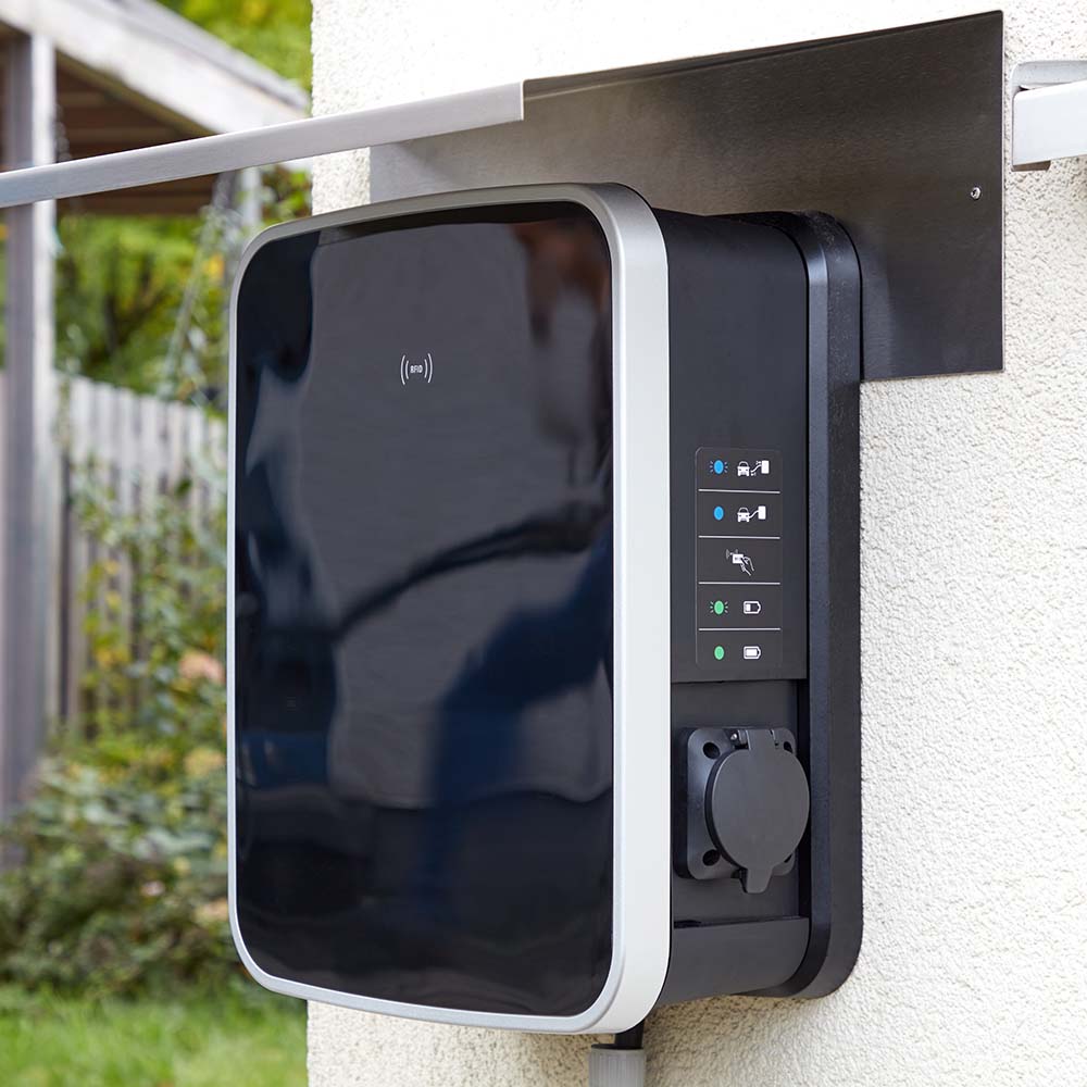 Eine schwarze Ladestation, die an der Hauswand befestigt ist